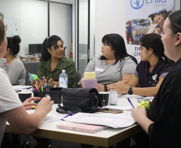 A group of teachers sitting around a table having a discussion