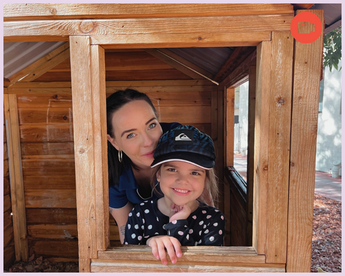 An educator and child inside a playhouse