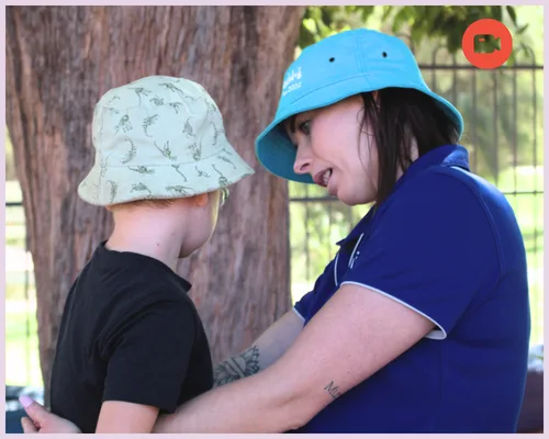An educator and child play outside