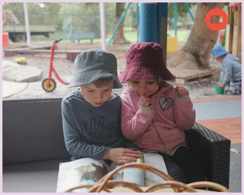 Two kids read a book together
