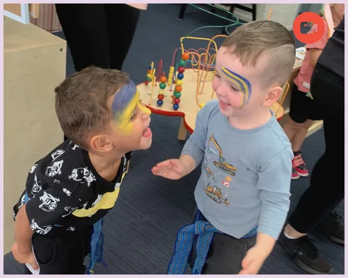 Two kids with face paint laugh together
