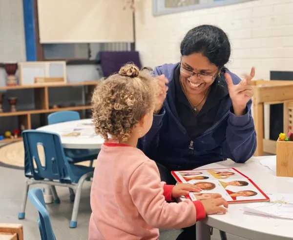 An educator teaches a child about facial expressions