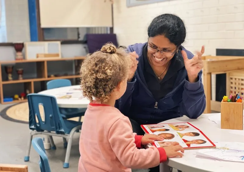 An educator teaches a child about facial expressions