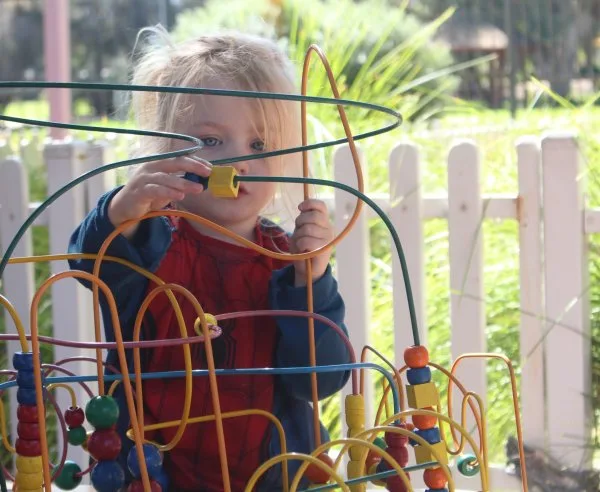 A child playing with blocks outside