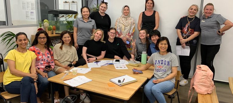 A group of staff members get together for a photo and smile inside