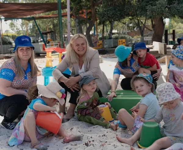 Children and educators building sandcastles in the sand pit