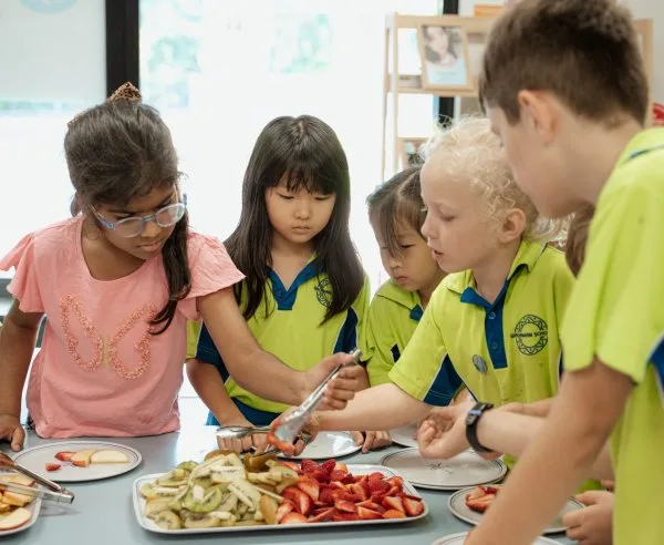 Children dish up their plates with healthy food and fruits